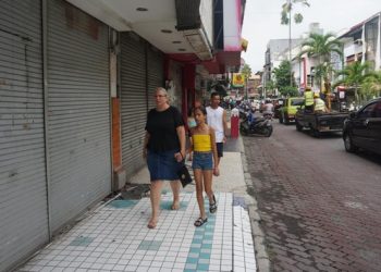 Wisatawan berjalan di kawasan pertokoan Kuta Square yang kini sepi karena banyak toko tutup. (Agus Eka Purna Negara/detikBali)
